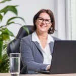 Regina Schickinger, Finanzexpertin und Gründerin von FRAUEN INVESTIEREN, am Laptop – deine Begleiterin im Starter Paket